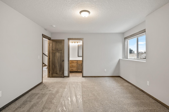 9971 14th Cir NE, Saint Michael, MN 55376 - unfurnished bedroom with a textured ceiling, light colored carpet, baseboards, and ensuite bathroom