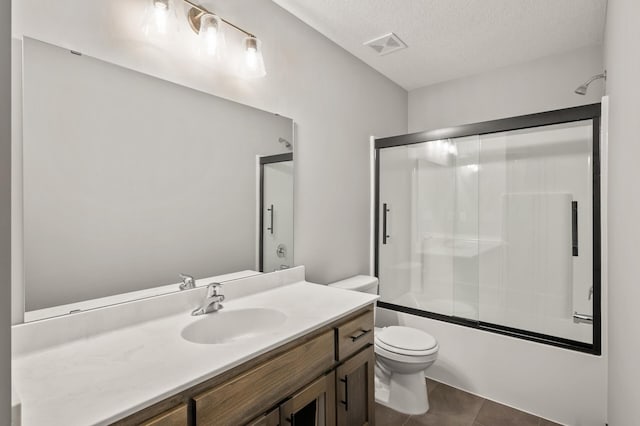 9971 14th Cir NE, Saint Michael, MN 55376 - bathroom with vanity, bath / shower combo with glass door, toilet, a textured ceiling, and tile patterned floors