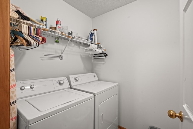 laundry area featuring a textured ceiling and washer and dryer