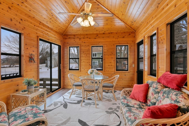 sunroom / solarium with lofted ceiling, wooden ceiling, and ceiling fan