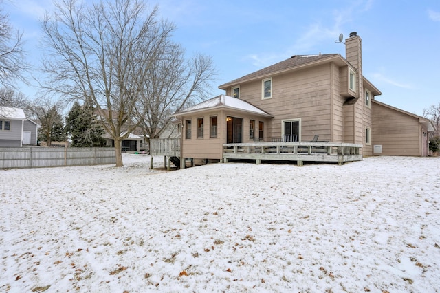 snow covered house featuring a deck