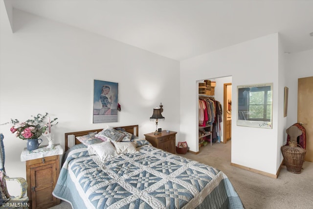 bedroom featuring a walk in closet, light carpet, and a closet