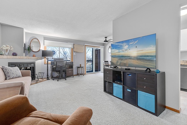 living room featuring ceiling fan, light carpet, and a textured ceiling