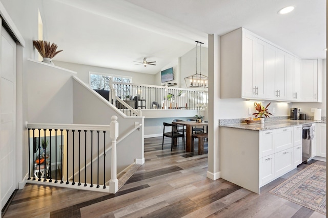 kitchen featuring hanging light fixtures, lofted ceiling with beams, white cabinets, and light wood-type flooring