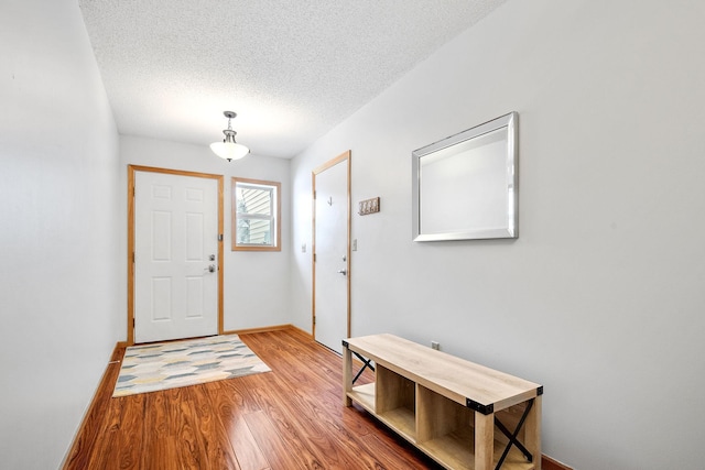 foyer entrance with hardwood / wood-style floors and a textured ceiling