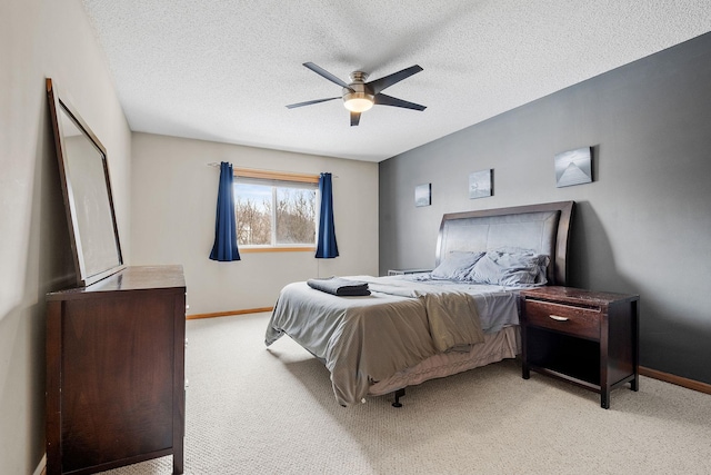 carpeted bedroom with ceiling fan and a textured ceiling