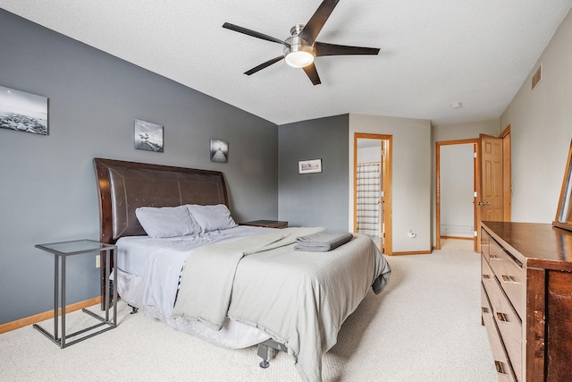 bedroom with ceiling fan, light colored carpet, and a textured ceiling