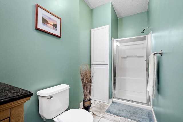 bathroom featuring a shower with shower door, toilet, and a textured ceiling