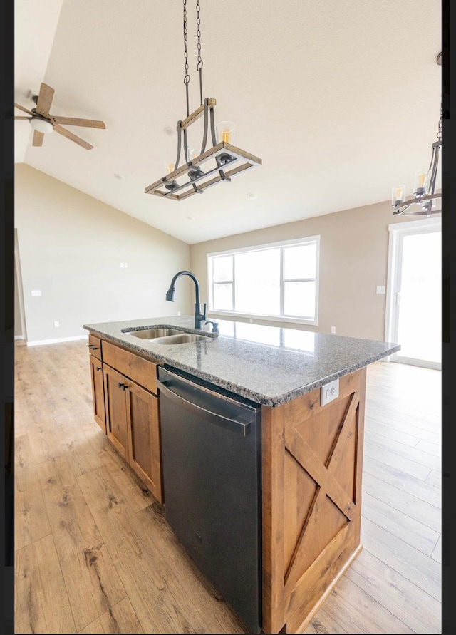 kitchen featuring dishwasher, an island with sink, sink, light wood-type flooring, and stone counters