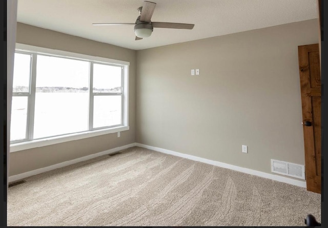 spare room featuring ceiling fan and carpet flooring