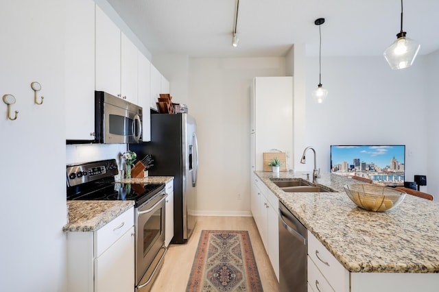 kitchen featuring white cabinetry, stainless steel appliances, sink, backsplash, and hanging light fixtures