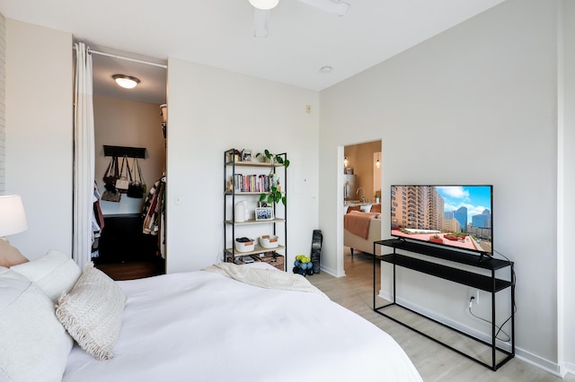 bedroom featuring ceiling fan, light hardwood / wood-style flooring, a closet, and ensuite bathroom