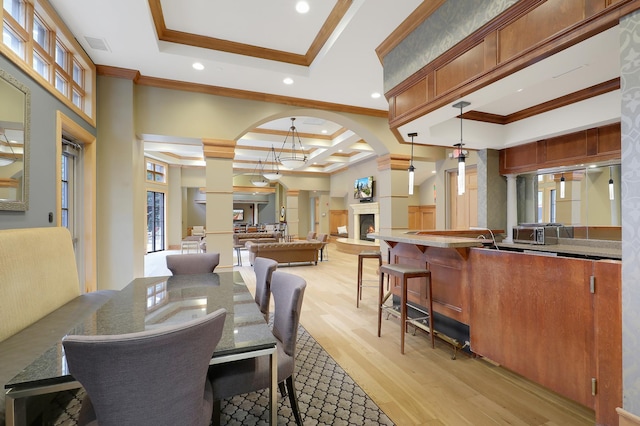 dining area with a tray ceiling, ornamental molding, coffered ceiling, light hardwood / wood-style floors, and beamed ceiling