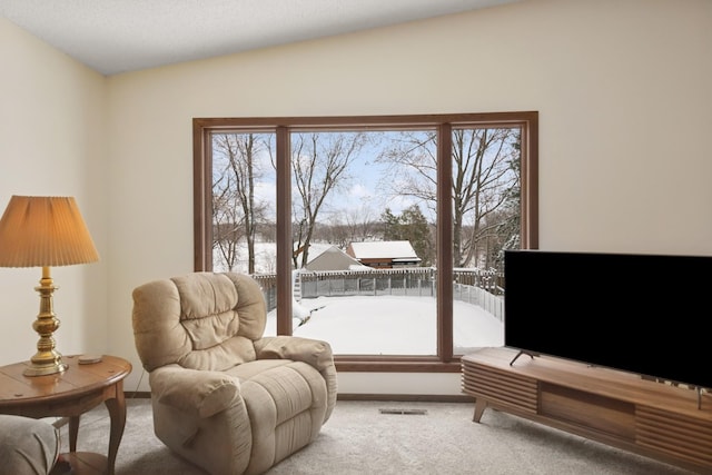 living area featuring visible vents, baseboards, carpet, and lofted ceiling