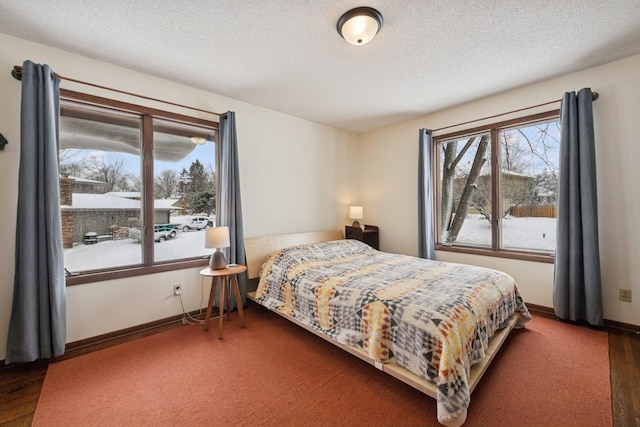 bedroom with wood finished floors, baseboards, and a textured ceiling