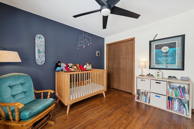 bedroom with a ceiling fan, wood finished floors, and a closet