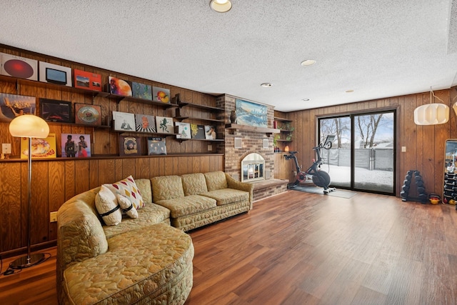 living area with a textured ceiling, wood finished floors, and a fireplace