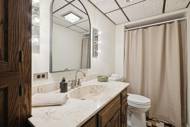 full bath with a drop ceiling, toilet, vanity, and a shower with curtain