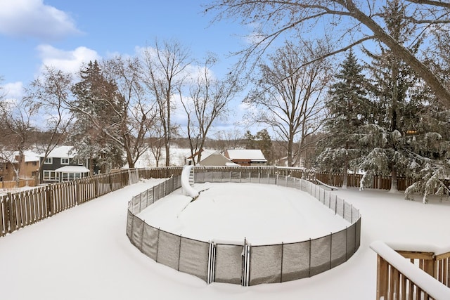 yard layered in snow with a fenced backyard