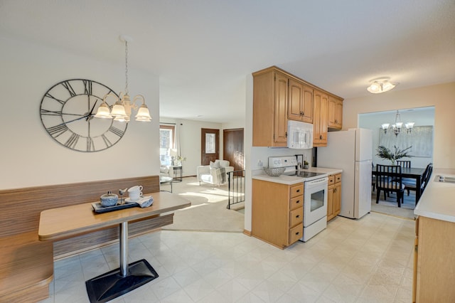 kitchen featuring white appliances, pendant lighting, and a notable chandelier