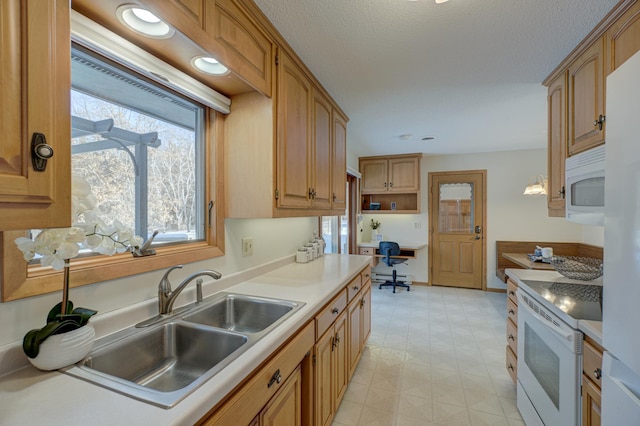 kitchen with sink, white appliances, a textured ceiling, and a baseboard heating unit