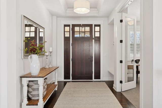 entrance foyer featuring baseboards, a raised ceiling, dark wood-style flooring, crown molding, and french doors