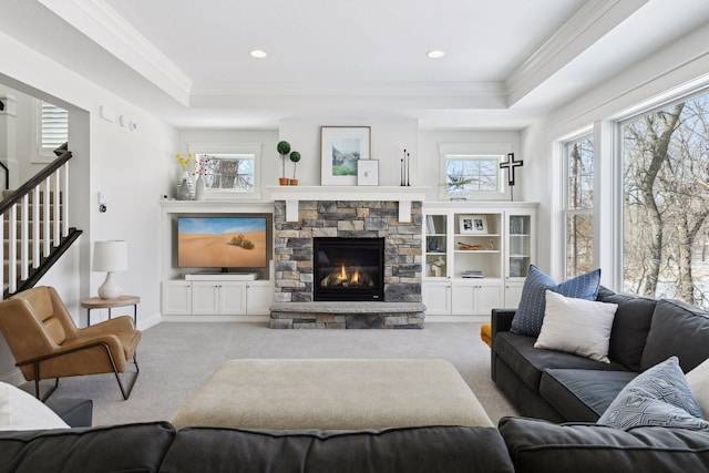 living room featuring carpet, a tray ceiling, and crown molding