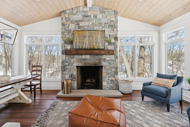 interior space featuring plenty of natural light, vaulted ceiling, a stone fireplace, and wood finished floors