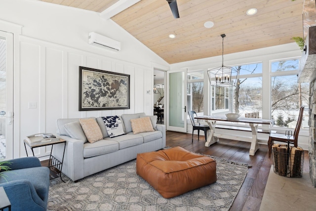 living area with plenty of natural light, wood finished floors, a wall mounted air conditioner, vaulted ceiling with beams, and a decorative wall