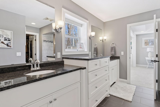 full bath featuring visible vents, a spacious closet, vanity, baseboards, and tile patterned floors