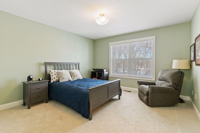 bedroom with light colored carpet and baseboards