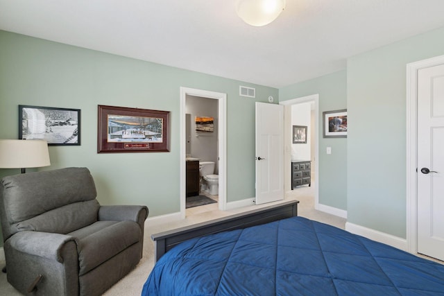 bedroom with carpet, visible vents, ensuite bath, and baseboards
