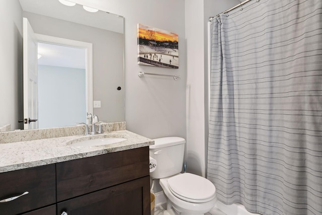 bathroom with curtained shower, vanity, and toilet