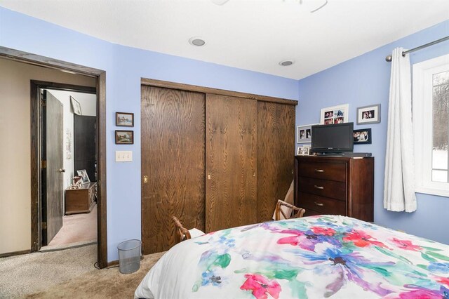 bedroom with a closet and light carpet