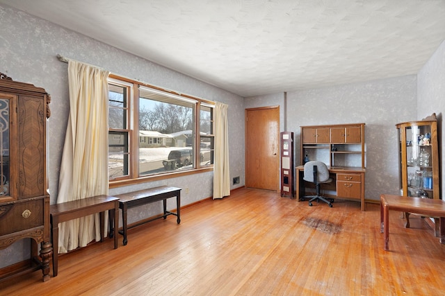 home office with light hardwood / wood-style flooring