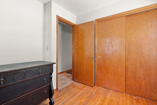 unfurnished bedroom with a closet and light wood-type flooring