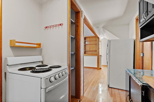 kitchen featuring white electric range oven, stainless steel refrigerator, and light hardwood / wood-style floors