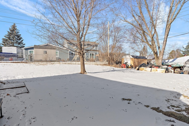 yard covered in snow with a storage shed