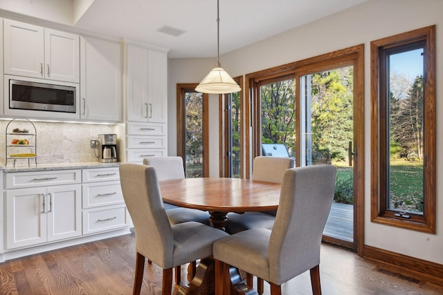 dining space with dark hardwood / wood-style flooring