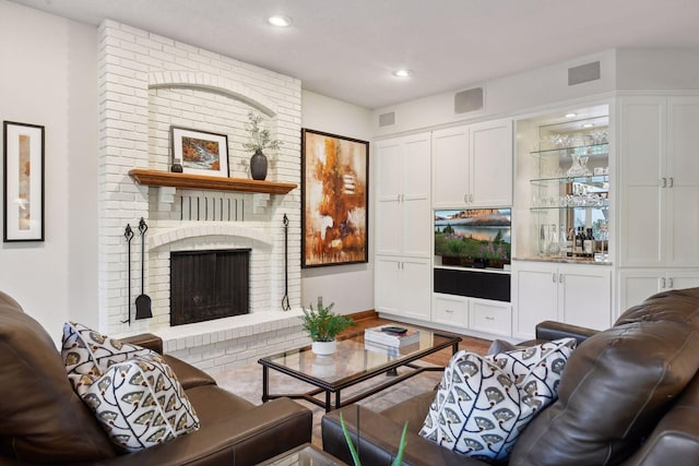 living room featuring hardwood / wood-style flooring and a brick fireplace