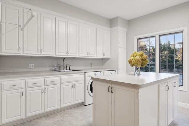 washroom with sink, washer / dryer, a healthy amount of sunlight, and cabinets