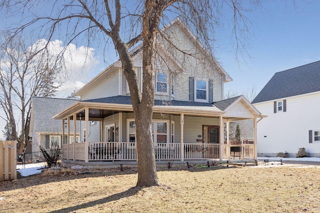 farmhouse-style home with a porch, roof with shingles, and fence