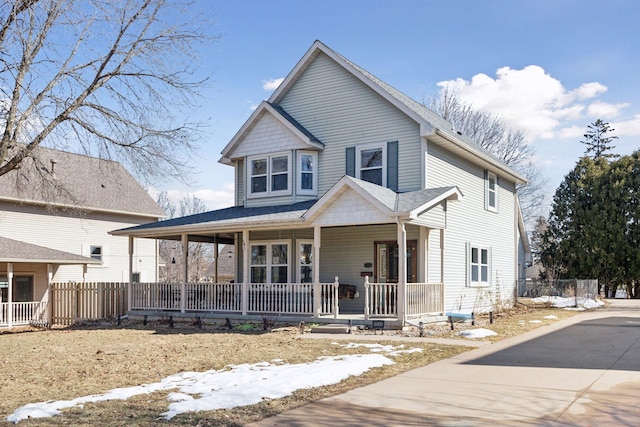 view of front of home featuring a porch and fence