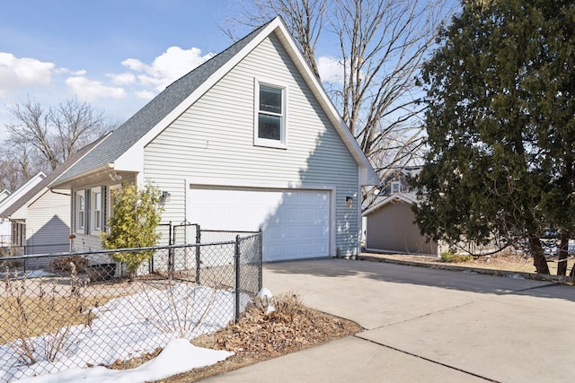 view of home's exterior with an attached garage, driveway, and fence