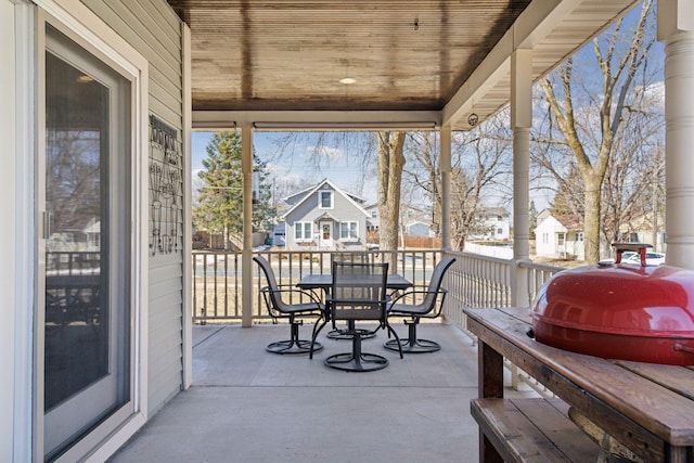 view of patio featuring grilling area, outdoor dining space, and a residential view