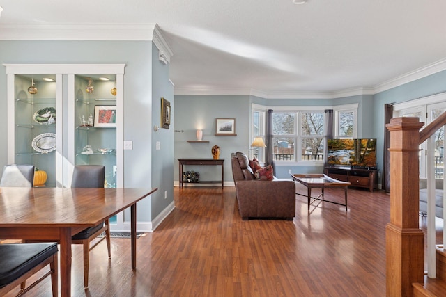 living area featuring wood finished floors, baseboards, and ornamental molding