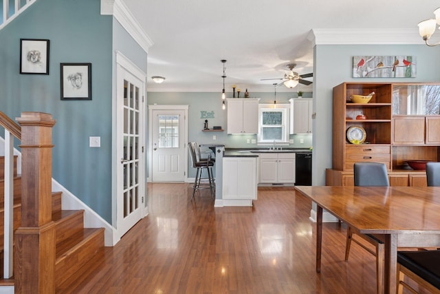 dining room with stairs, crown molding, wood finished floors, and ceiling fan