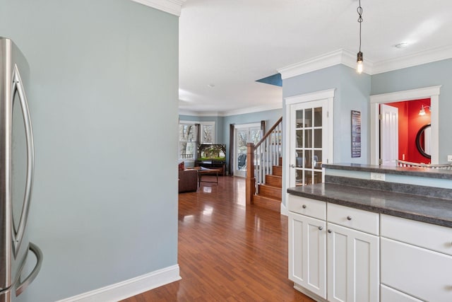 kitchen featuring dark countertops, white cabinets, dark wood-style flooring, and ornamental molding