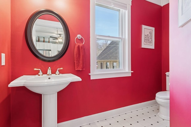 half bathroom featuring toilet and baseboards