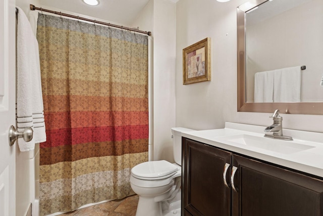 full bath featuring vanity, toilet, stone finish flooring, and a shower with curtain